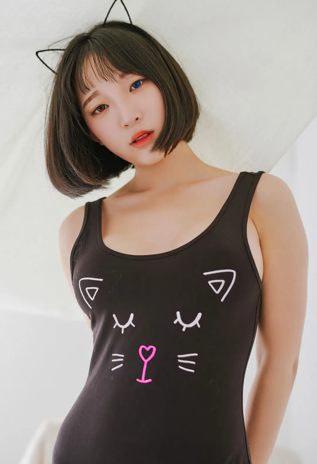 姜仁卿 Kang Inkyung 穿黑色猫咪图案服装站在浅色背景前