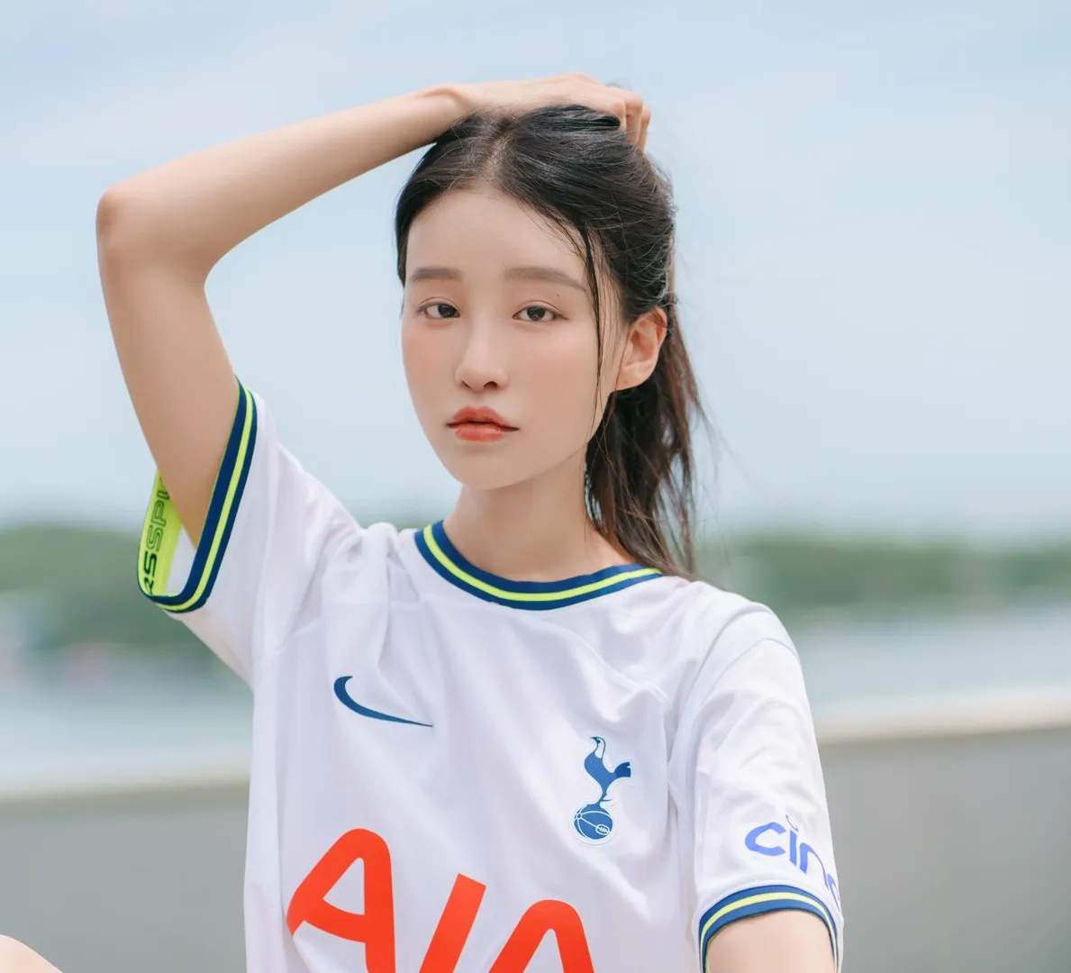 Leesnoww이설穿白色运动风上衣抬起手臂的户外照片