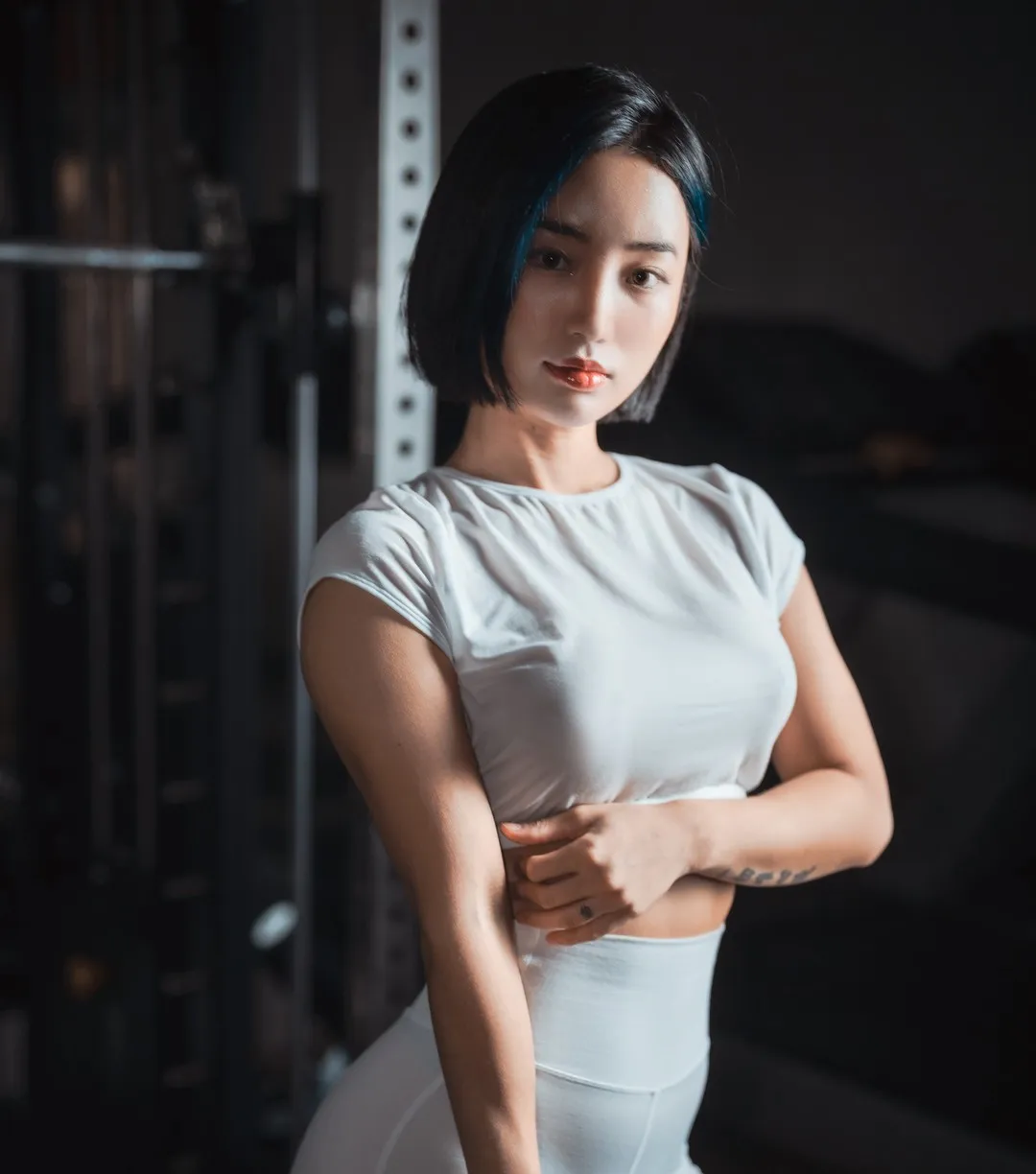 BootyQueen海外Coser BootyQueen白色服装照片，深色背景、侧面光线和人物轮廓形成视觉对比