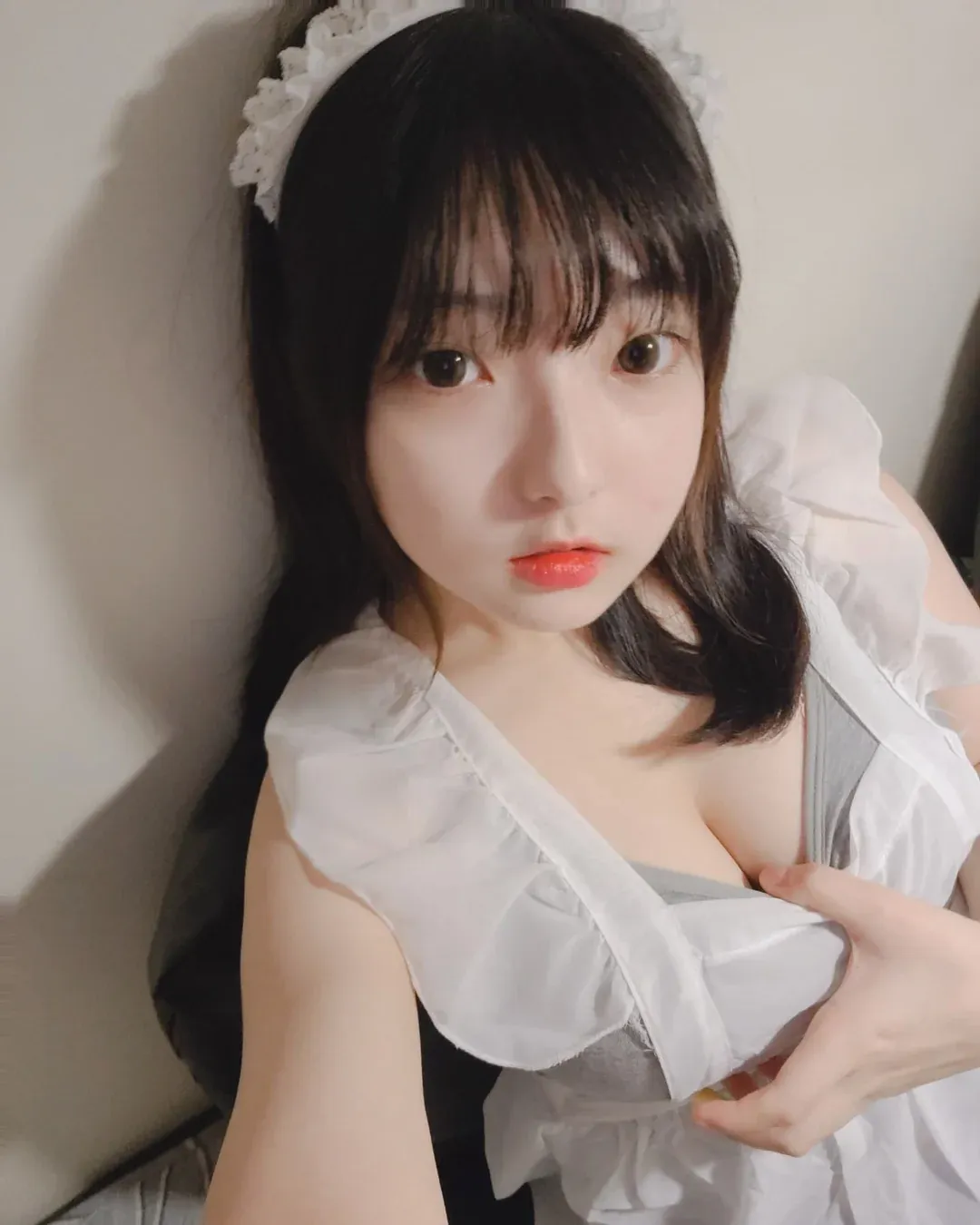Hansom(한솜)海外名称与作品 Hansom(한솜)白色服装近景照片,黑色发丝和室内背景形成对比