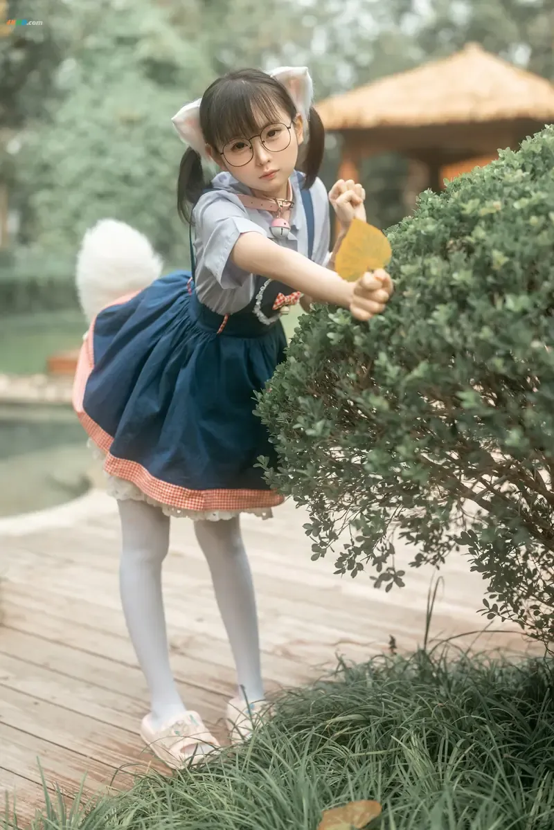 三刀刀Miido cosplay海外名称与作品 三刀刀Miido户外角色扮演造型，黑色双马尾与蓝色裙装搭配园林场景