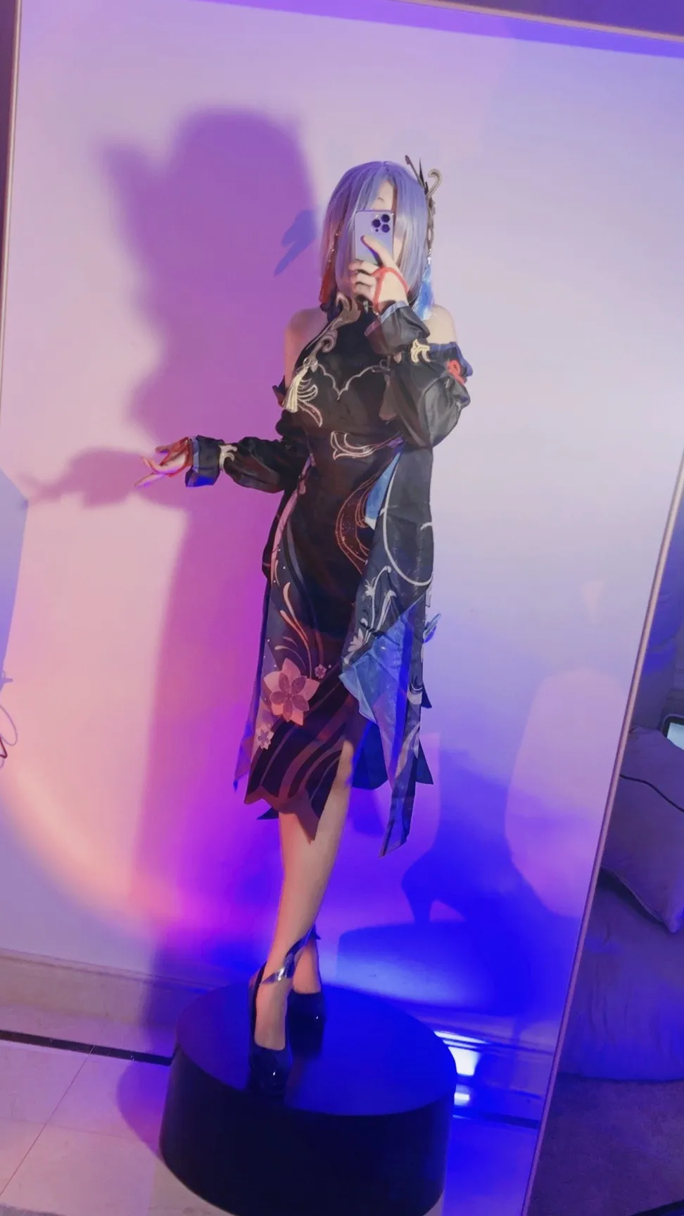 屑雪雪鸭海外名称识别与Cosplay作品 屑雪雪鸭Cosplay造型照片,人物留浅色发型并穿着黑色装饰服装,处于紫蓝色灯光环境中