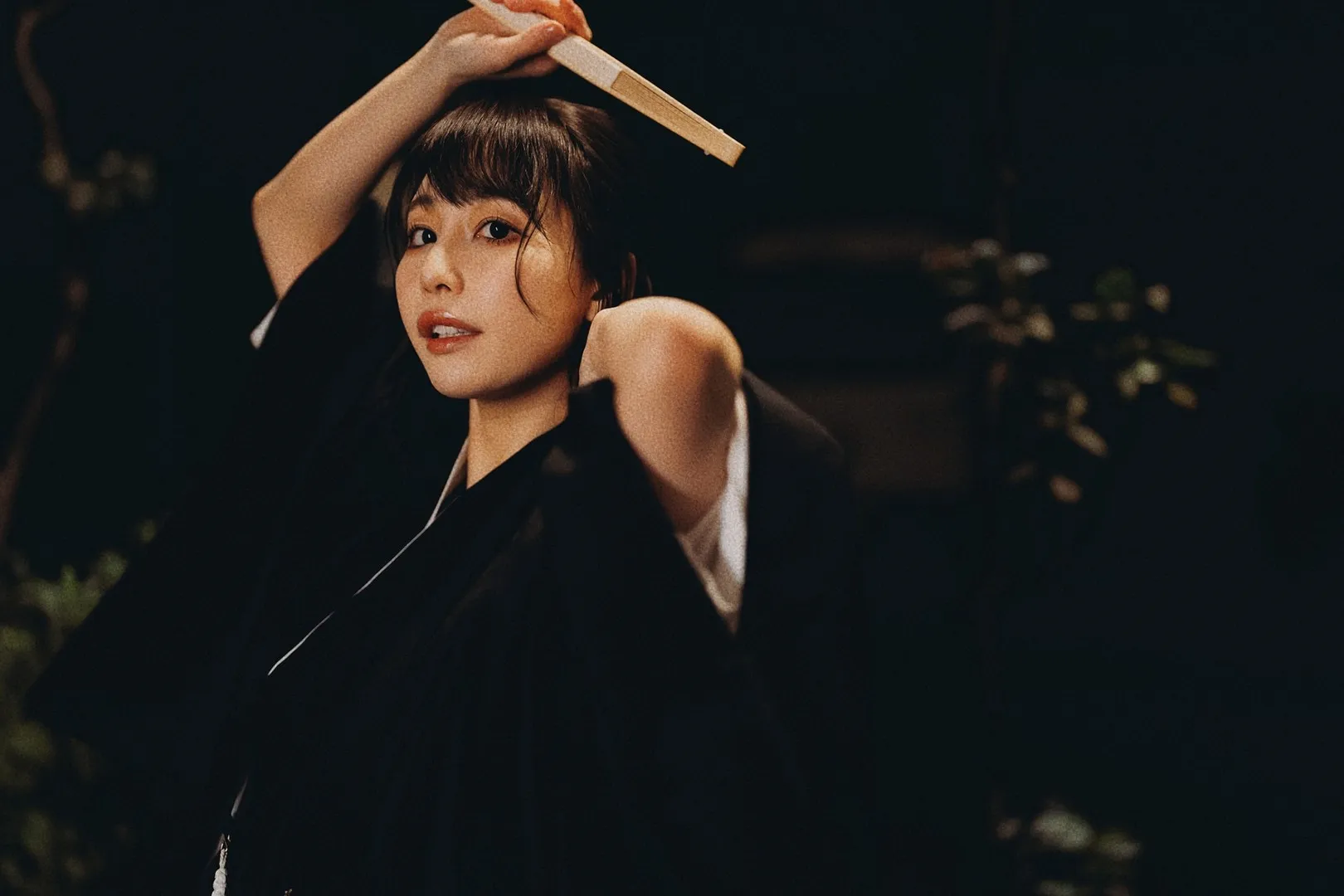 彩美旬果 Ayami Shunka 海外名称与作品 彩美旬果黑色服装造型照片，人物留有齐刘海发型，手持浅色物件，暗色背景下呈现简洁视觉效果