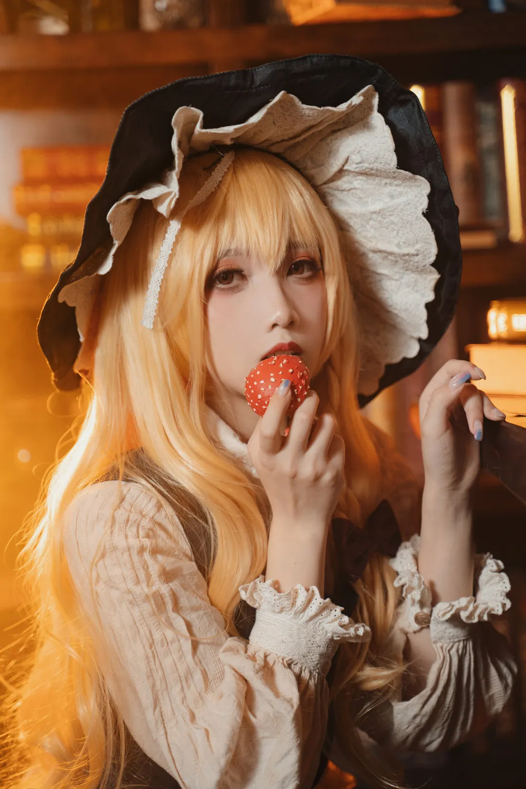 小和甜酒 cosplay 海外名称与作品 小和甜酒公开Cosplay造型照片，金色长发搭配黑色宽檐帽和浅色服装，手持红色点心，暖色环境光下呈现角色化造型