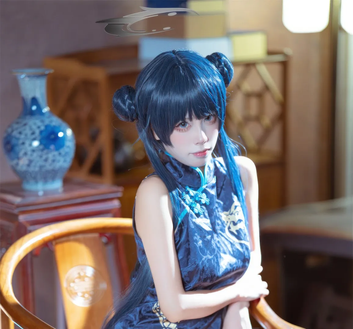 三無人型 cosplay海外名称与写真 蓝色长发角色造型照片,人物坐姿与室内背景可见