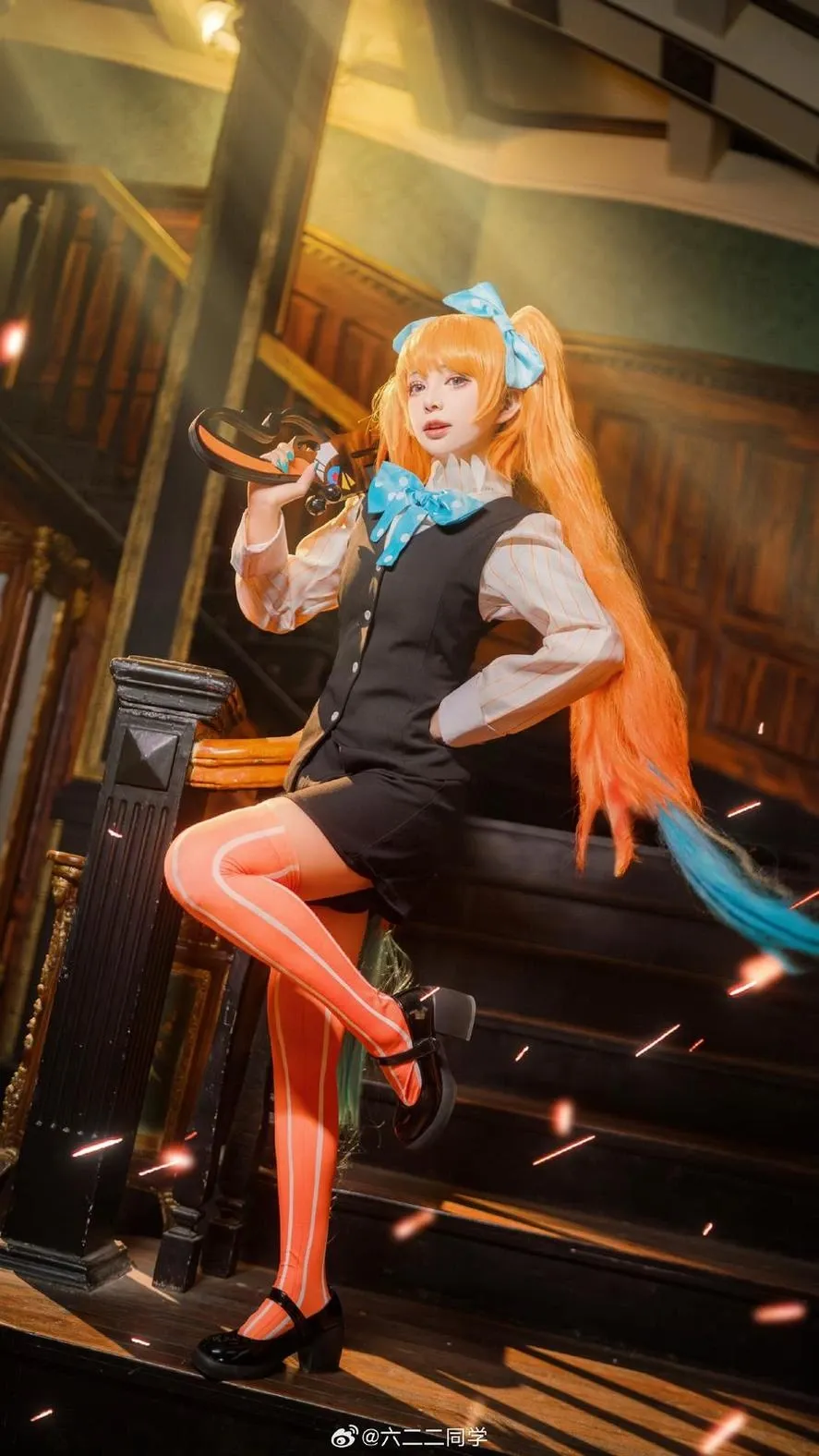 六二二同学海外Coser 六二二同学橙色长发角色造型，身穿黑白服装并处于室内舞台环境
