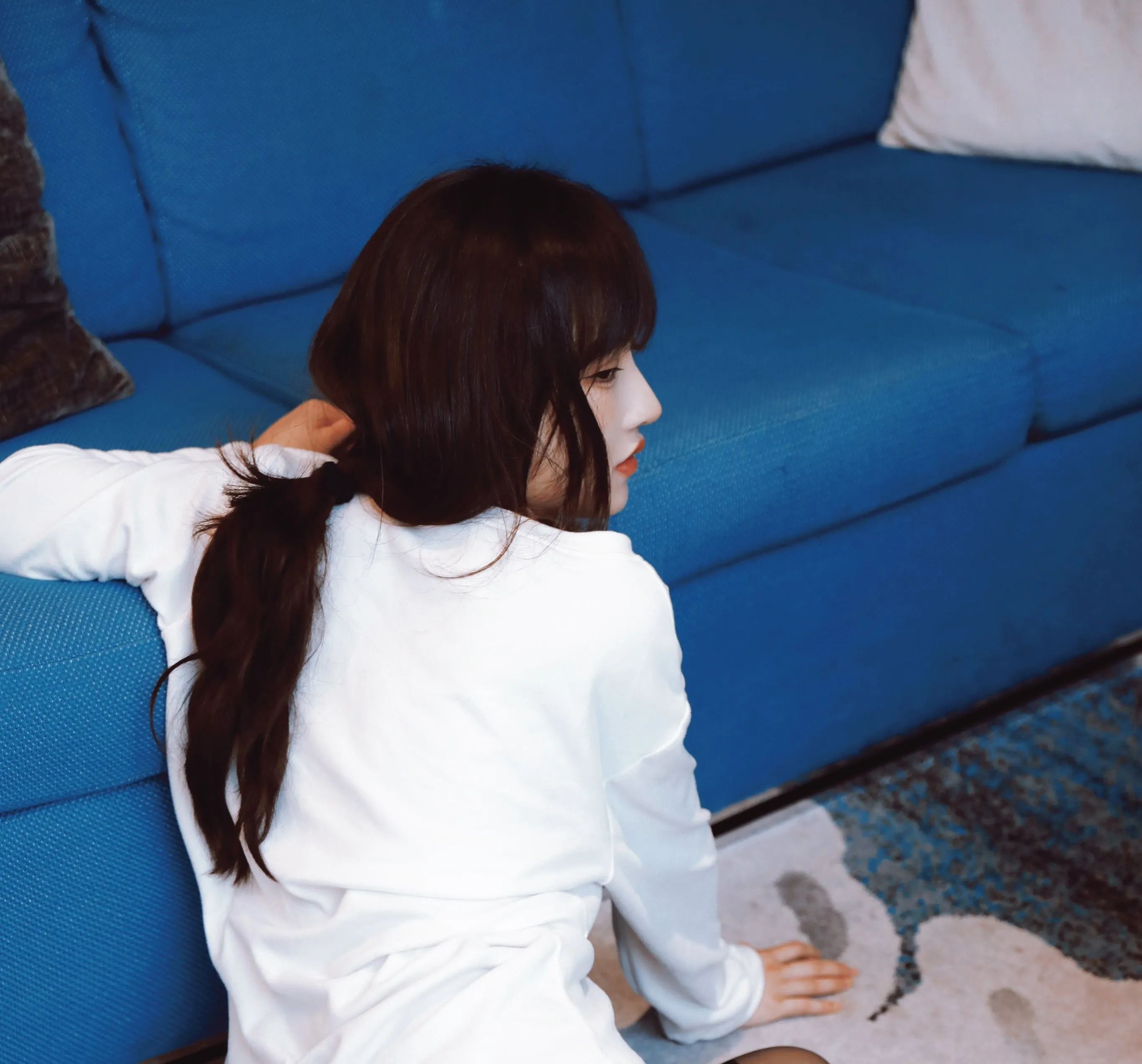 三青叶子 cosplay跨语言名称与写真 室内蓝色沙发环境中的人物侧面照片，呈现休闲服装和空间关系