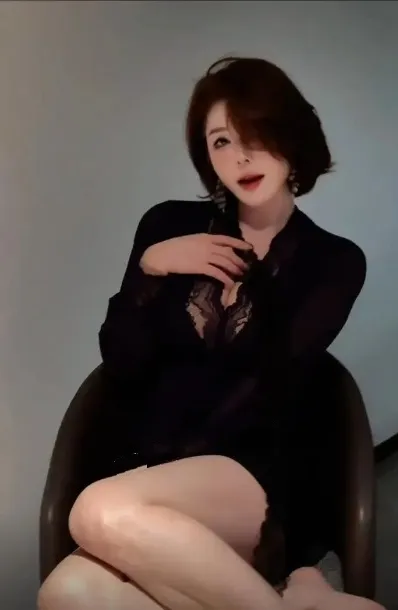 手什么葵海外名称与作品 手什么葵 cosplay与写真视觉导读 手什么葵短发黑色服装坐姿造型照片,展示室内人物轮廓