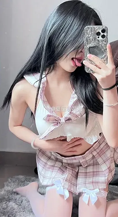 夏笙姑娘海外名称识别与代表作品整理 黑色长发人物穿浅色上衣和粉白格纹短裤,在灰色绒面地毯上用手机自拍