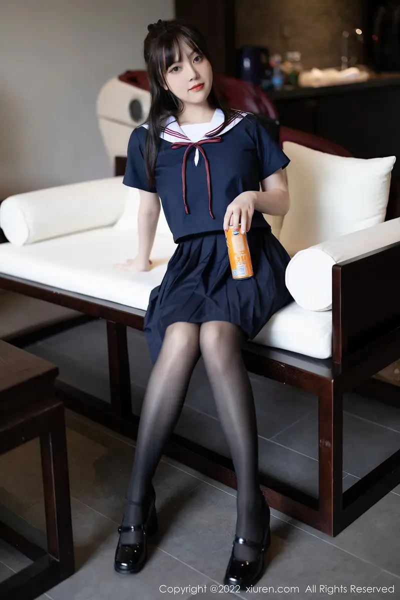 豆瓣酱身着深藏青水手服短裙手持橙色罐装饮料坐在白色软垫长木椅上_01