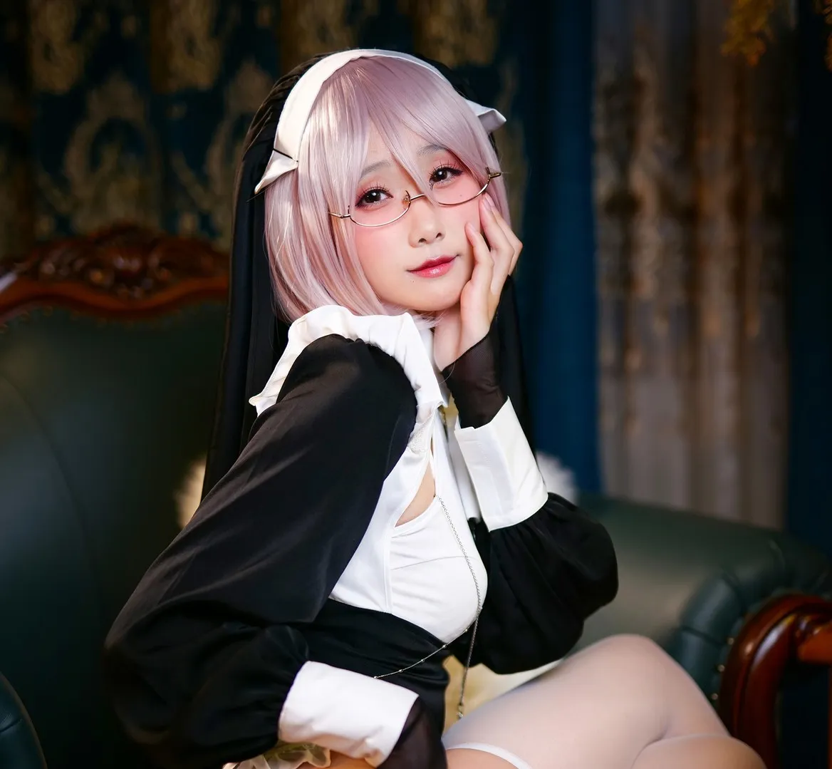 曉美媽名称辨识 粉色短发、细框眼镜与黑白角色服饰的室内坐姿造型