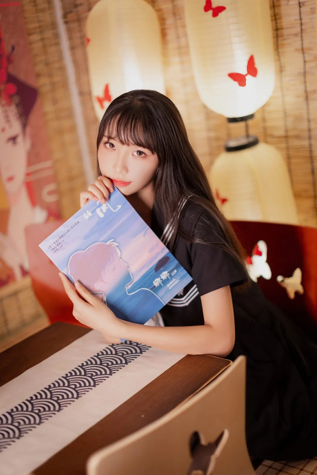 西瓜少女身着黑色短袖水手服手持画册坐于日式木桌旁_01