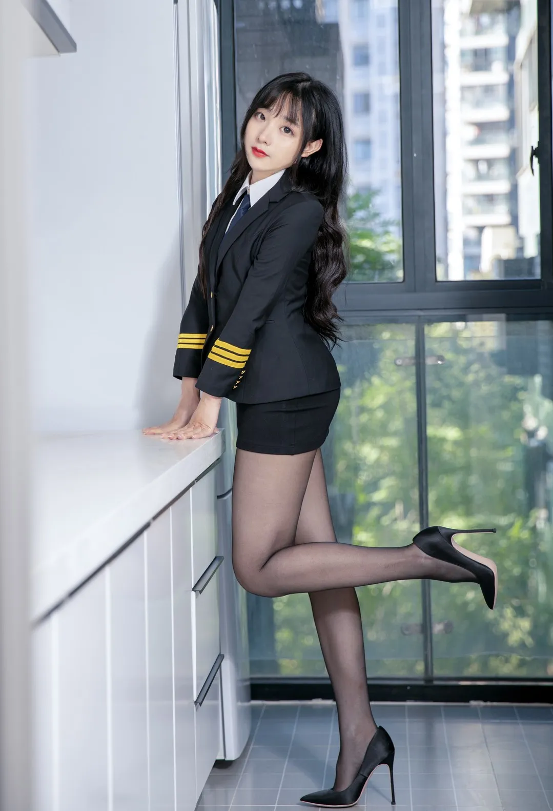 豪歌_倚靠白色橱柜身穿黑色双排扣制服配黑丝高跟鞋的全身立姿_02