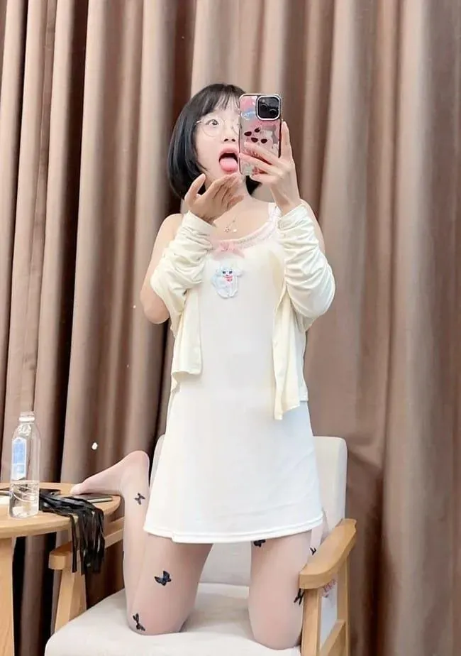 王胜利身穿白色吊带裙在室内持手机拍摄