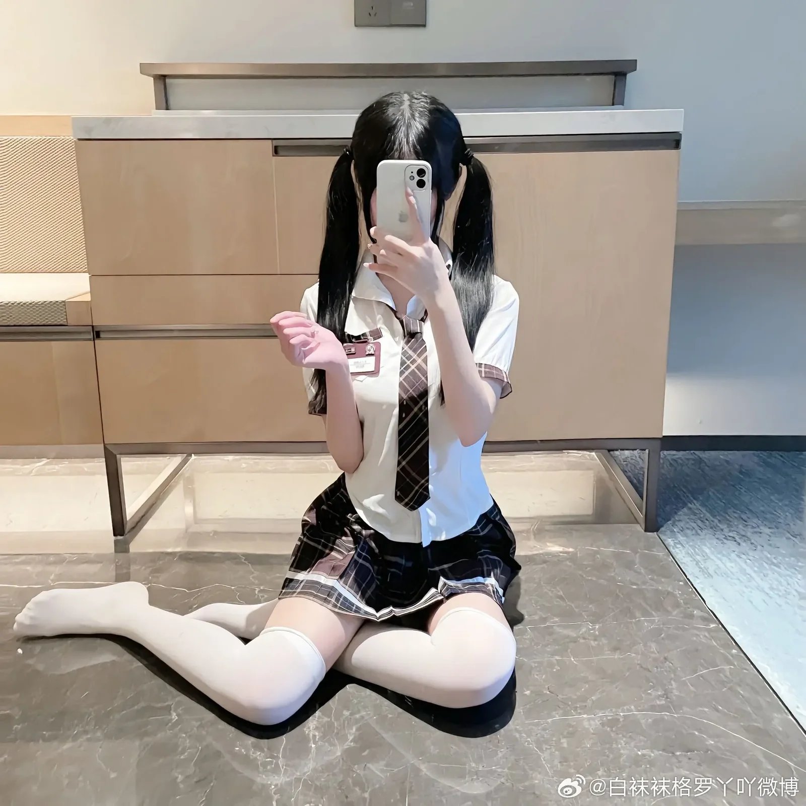 创作者身着短袖学生制服衬衫搭配白色长筒袜席地而坐