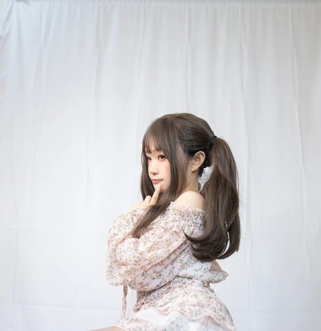 浅粉碎花一字肩连衣短裙双马尾食指点颊侧面姿态