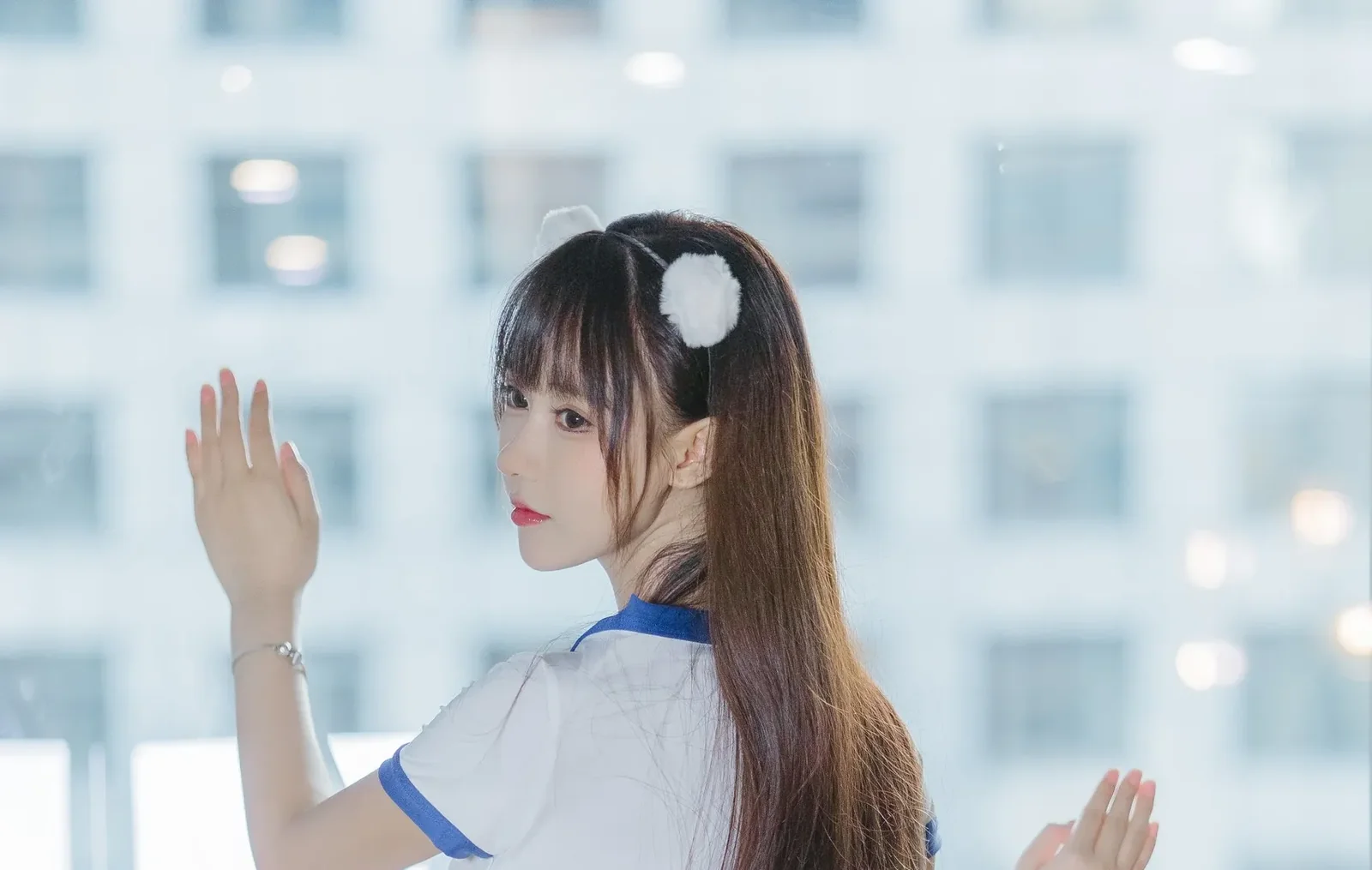 佩戴白色毛球发箍身穿白蓝拼色运动服在格子窗前的背身回眸