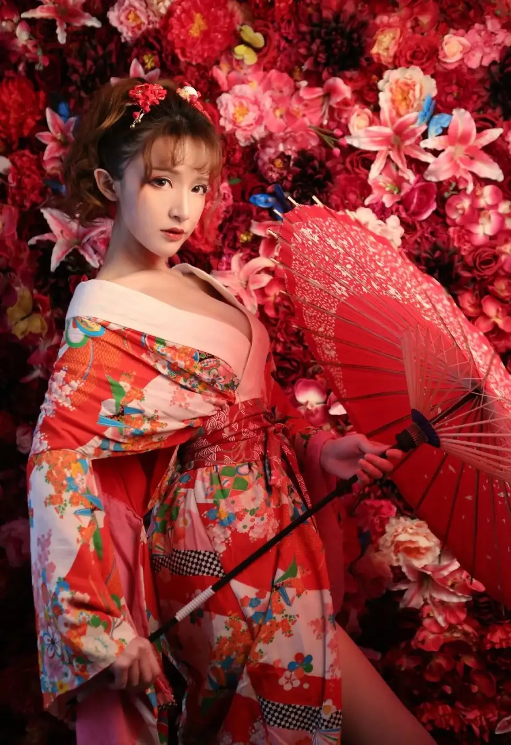 拿着红色纸伞站在红粉花墙前面的和服造型