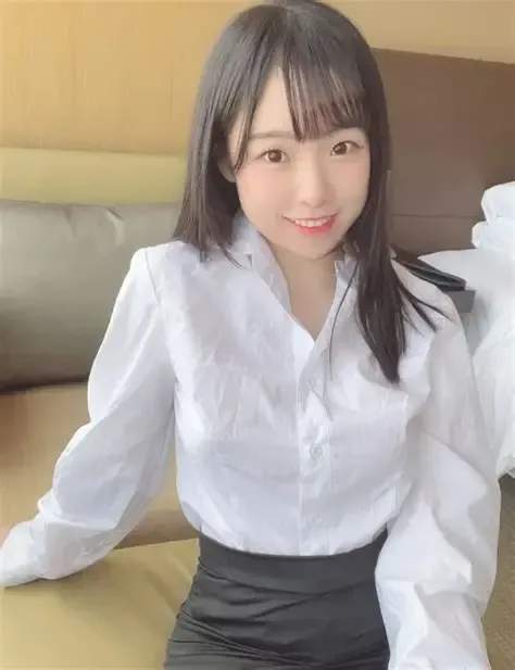 晴兒littlesshine跨语言名称识别与阶段性作品整理 黑色中长发女子穿白色长袖衬衫和深色下装坐在室内沙发前,背景为米黄与棕色墙面
