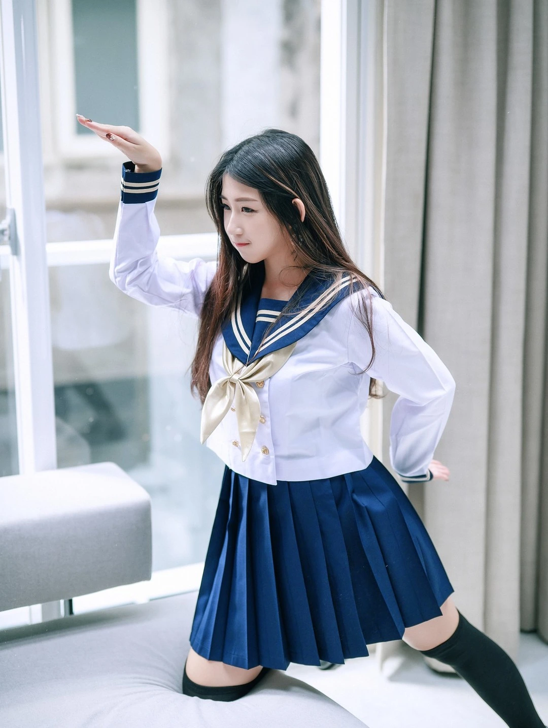 肉包Mini身着水手服单膝跪于灰沙发举手定格动作